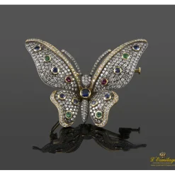 BROCHES / ALFILERES Broche-alfiler mariposa en oro amarillo y plata con rubíes, esmeraldas, zafiros y diamantes naturales.