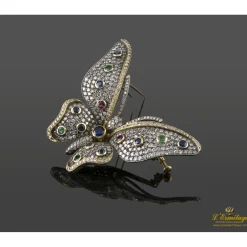 BROCHES / ALFILERES Broche-alfiler mariposa en oro amarillo y plata con rubíes, esmeraldas, zafiros y diamantes naturales.