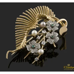 BROCHES / ALFILERES Broche en forma de ramo de flores y hoja realizado en oro amarillo y oro blanco. Presenta perlas, esmeraldas y brillantes.