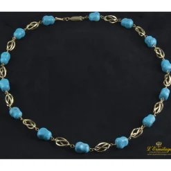 COLLARES Collar realizado en oro amarillo con eslabones en forma de jaula y presenta turquesas naturales.